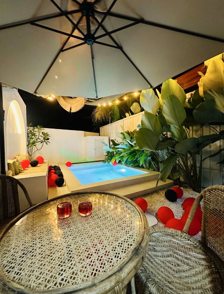 Villa Olu illuminated nighttime plunge pool, patio umbrella and rattan chairs in Galle